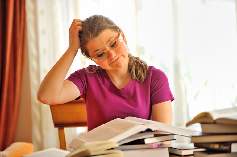 Woman scratching her head while studying